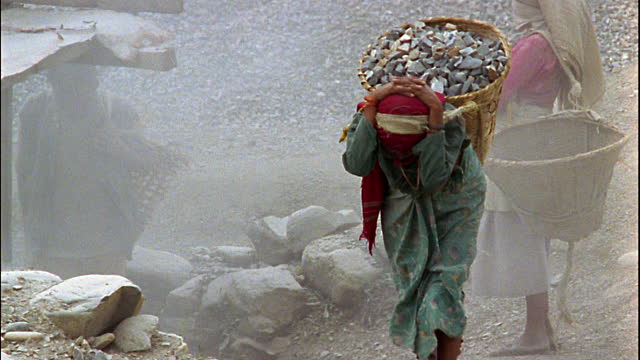 woman carrying stones